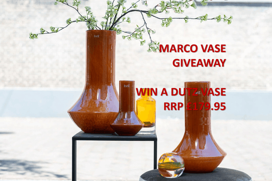 Marco vases displayed on tables with flowers and text promoting an easter giveaway for a chance to win