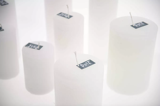 Set of white Lowlands Design candles with labels on top, arranged in a group