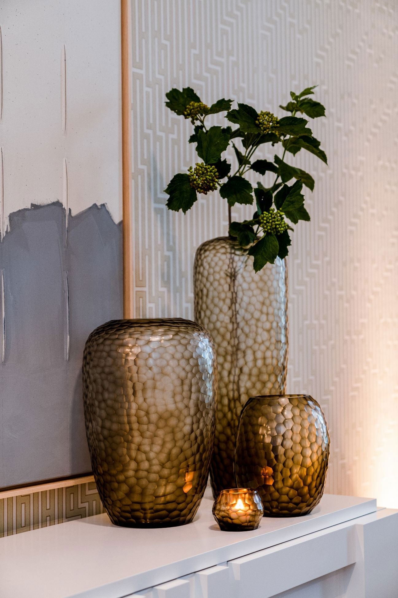 Lowlands Design glass candleholder set with textured pattern, including small lit candleholder on white surface