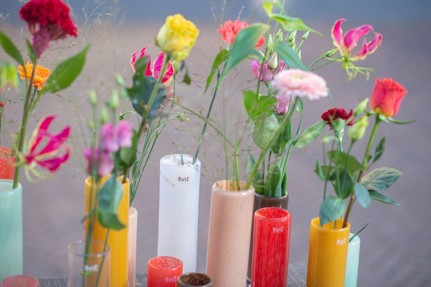 Lowlands Design cylinder vase collection featuring colourful vases with fresh flowers arranged in each vase