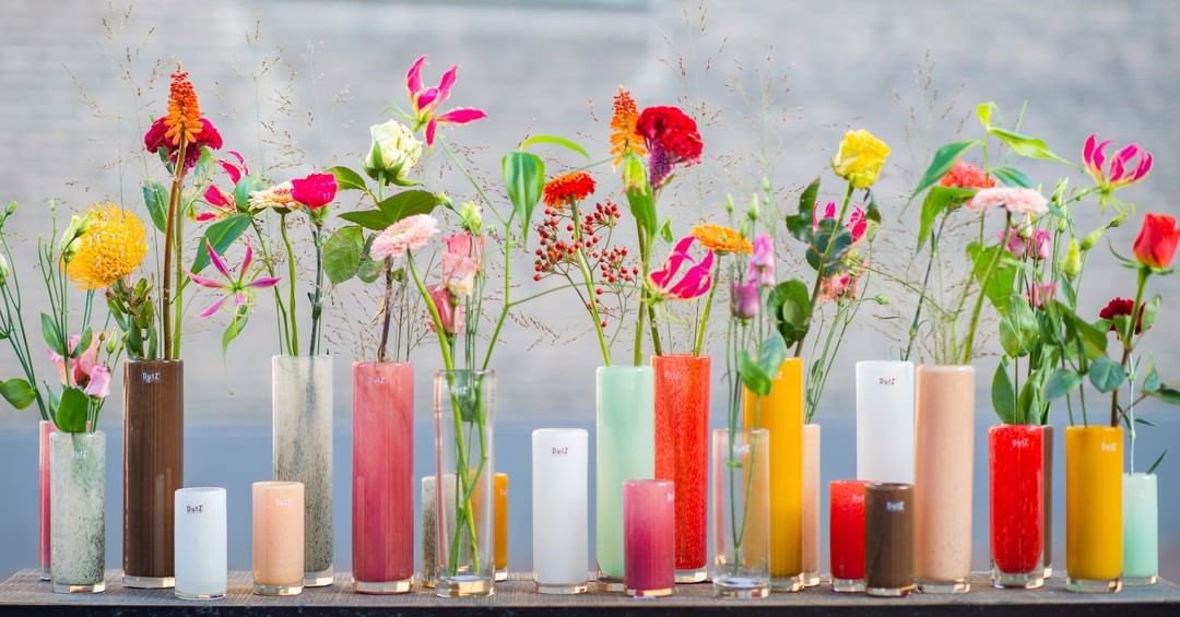Lowlands Design cylinder vase collection in various colours with decorative flowers arranged inside
