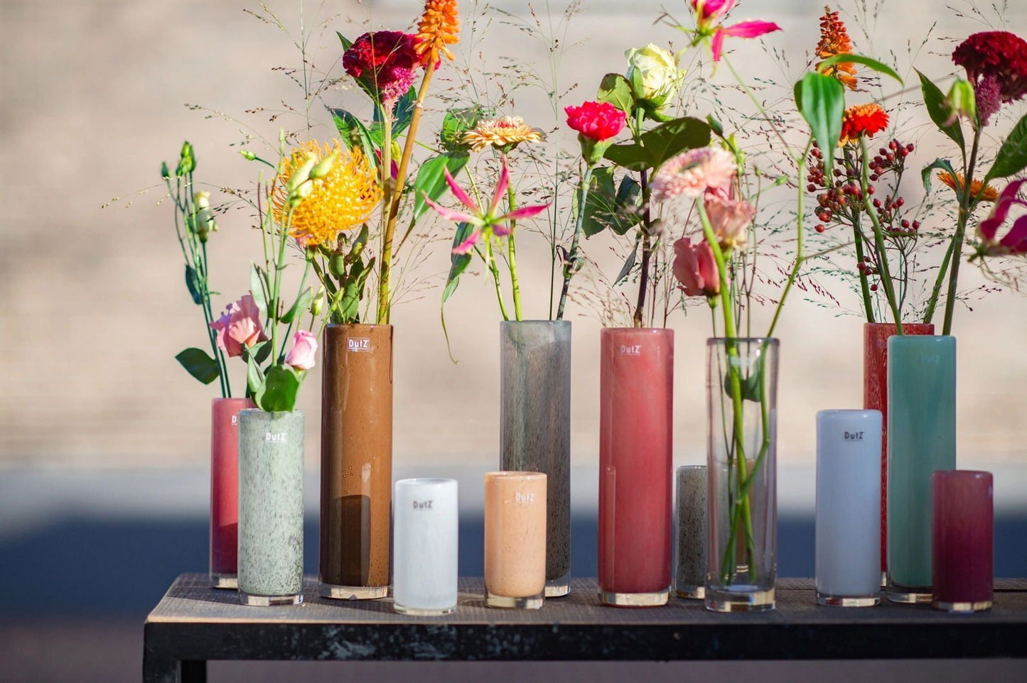 Lowlands Design colourful cylinder vase collection with various fresh flowers on display