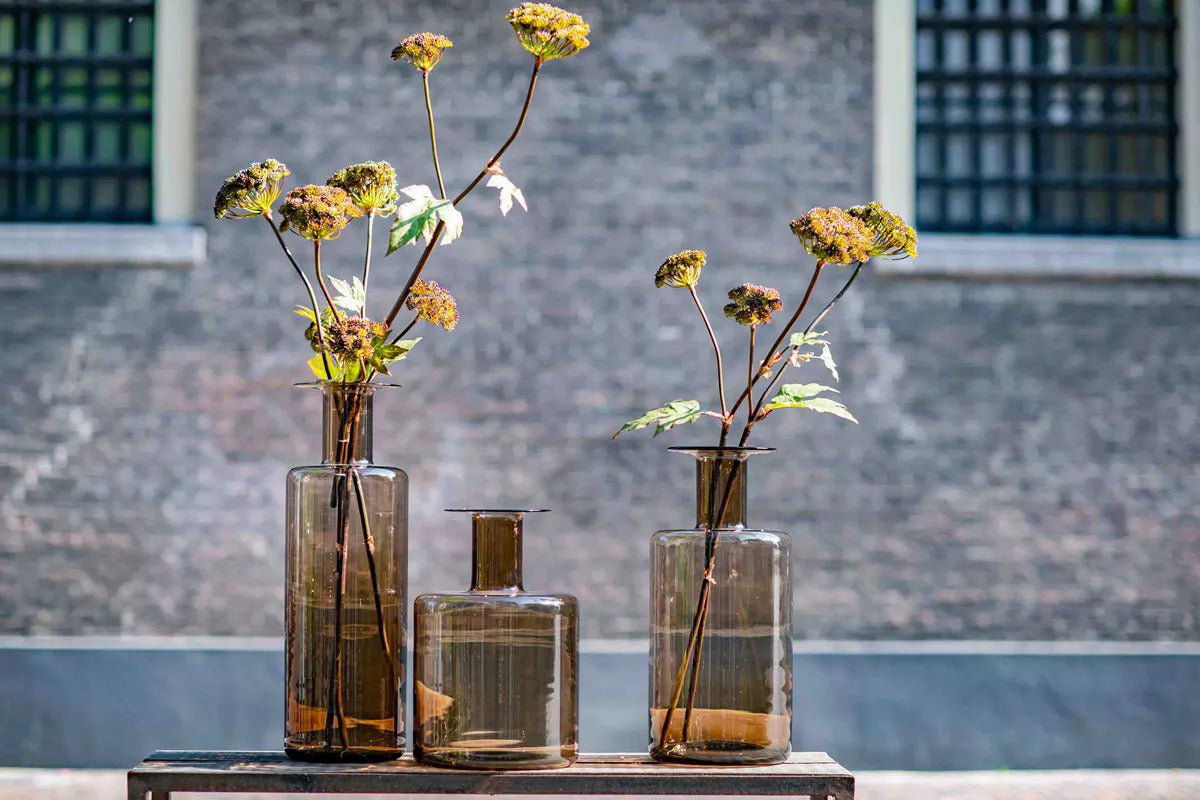 Lowlands Design brown glass bottle vase set with dried flowers on wooden table
