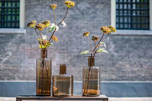 Lowlands Design brown glass bottle vase set with dried flowers on wooden table