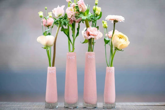 Lowlands Design pink glass Solifleur budvase set with assorted fresh flowers on grey surface