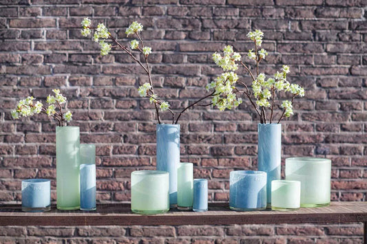 Lowlands Design candle votive cylinder set in blue and green with floral branches on wooden surface