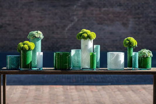 Lowlands Design cylinder vase collection in various sizes and green tones with floral arrangements
