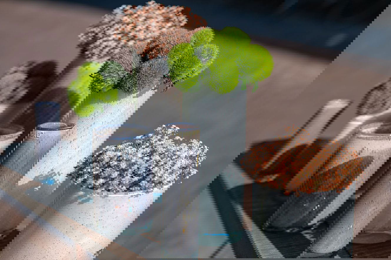 Lowlands Design cylinder vase set with modern white and gray textures holding green and white flowers