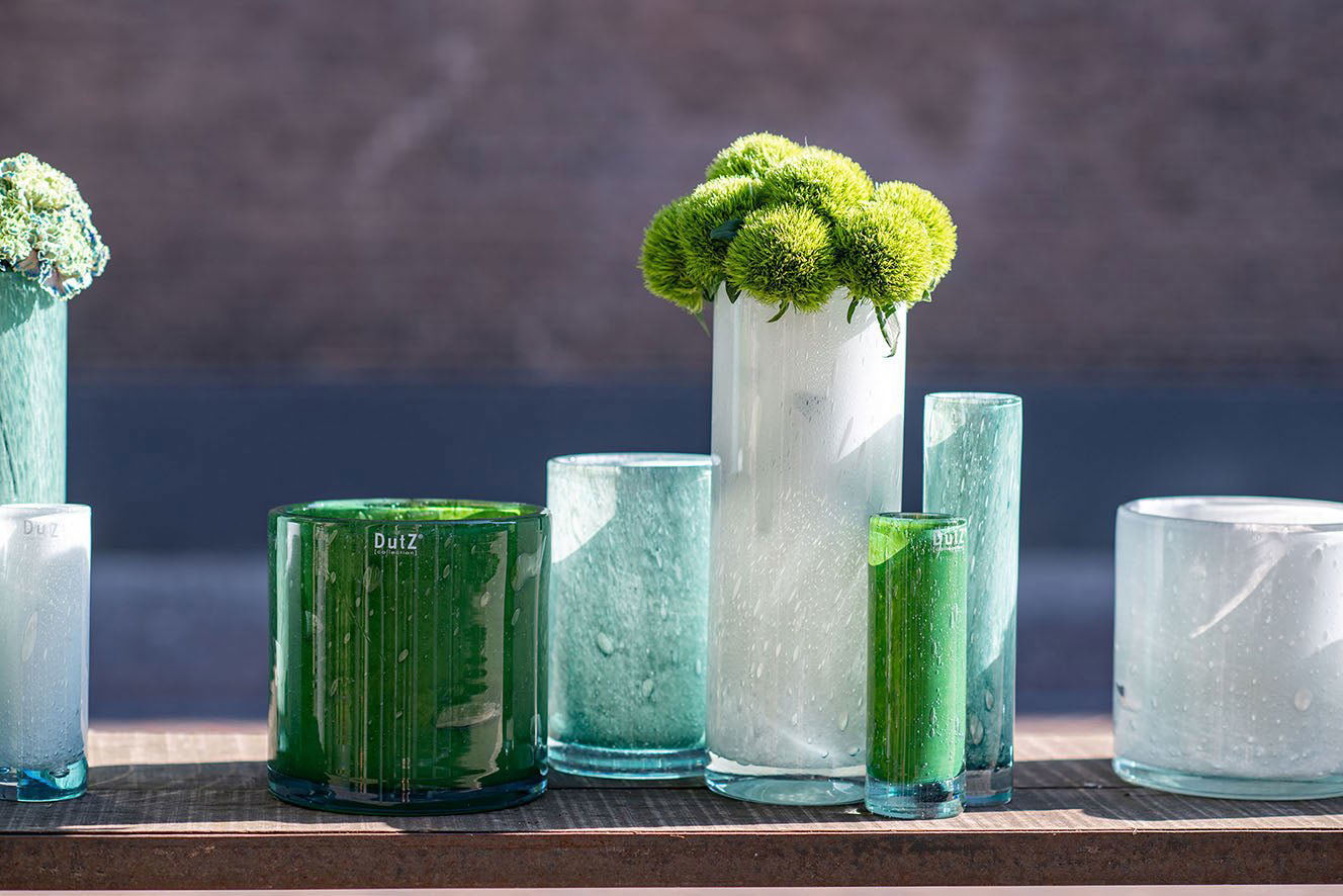 Lowlands Design cylinder vase collection in various sizes and colors displayed on a wooden surface