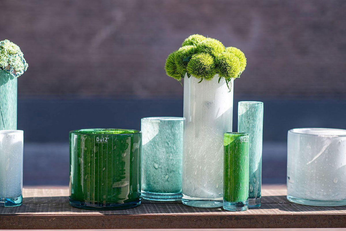 Lowlands Design cylinder vase collection in various sizes and colors displayed on a wooden surface