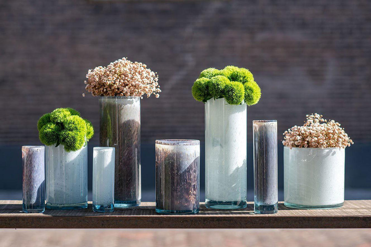 Set of Lowlands Design cylinder vase collection with various sizes holding green and white floral arrangements
