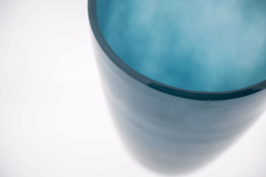 Blue glass flowervase by Lowlands Design with smooth cylindrical shape and translucent finish