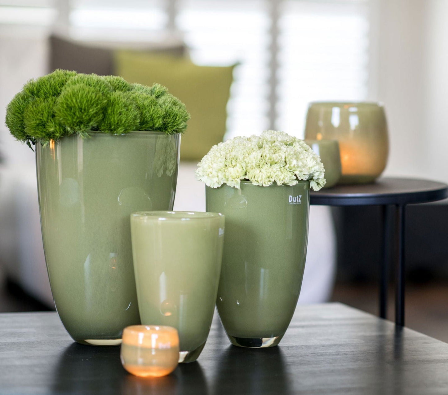 Lowlands Design green flowervase set with fresh flowers arranged on a black table in modern living room