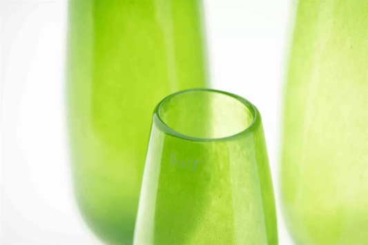 Close-up of a green glass vase by Lowlands Design with smooth translucent surface