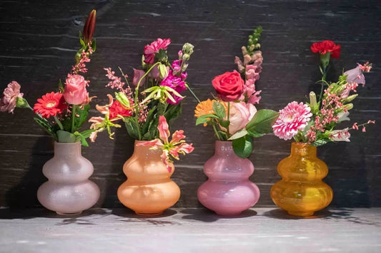 Lowlands Design handmade dutz vase set of four bulbous glass vases in pastel pink peach rose and amber with mixed flowers