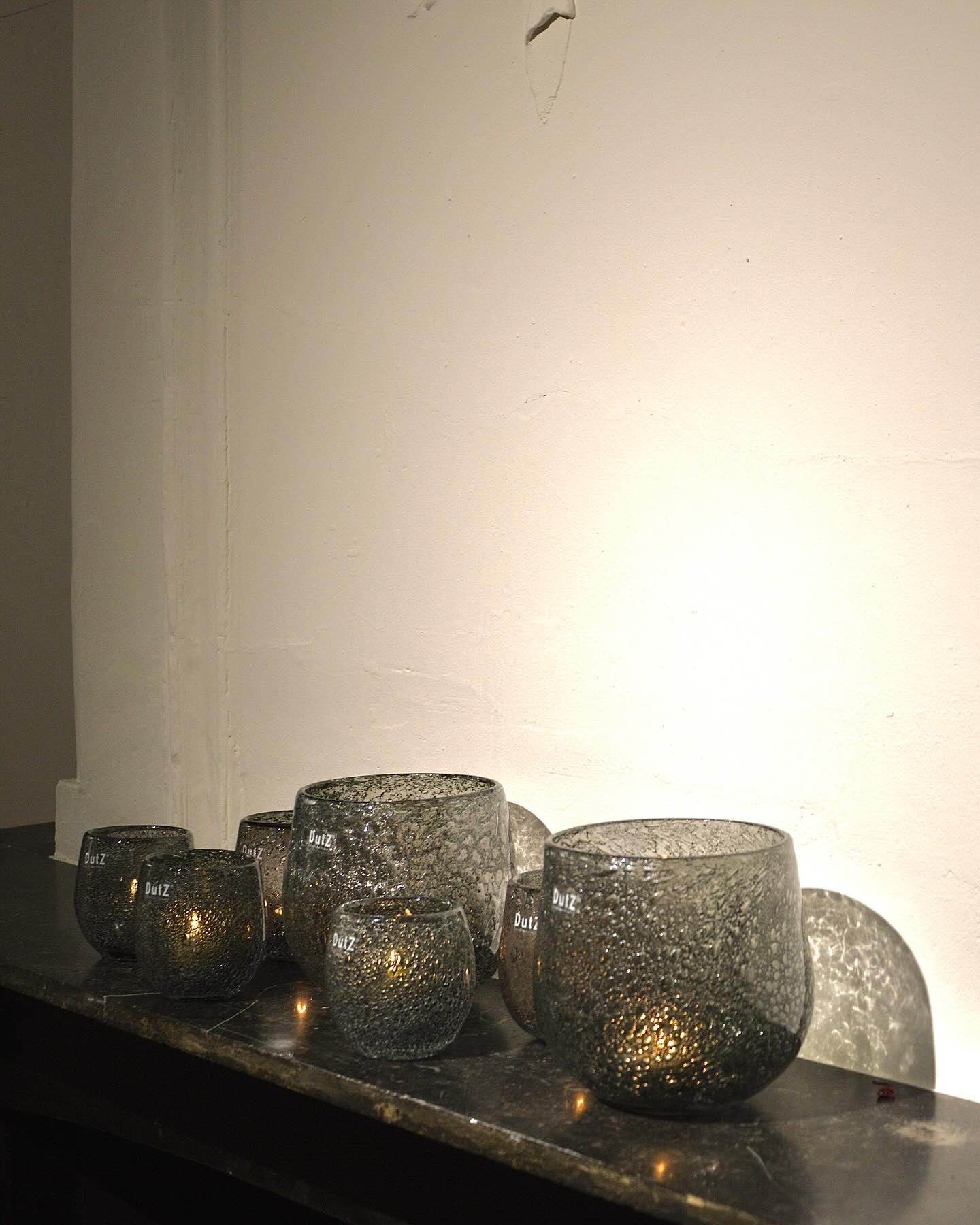 Lowlands Design smoky glass hurricane candleholder set with textured surface and warm candlelight glow