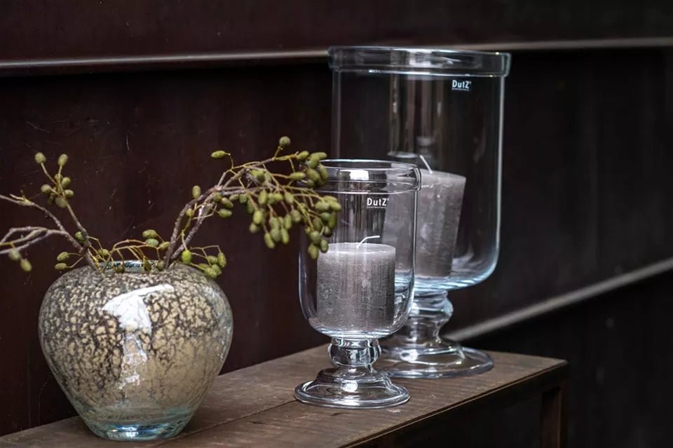 Lowlands Design clear glass hurricane vase candle holders with gray candles on wooden surface