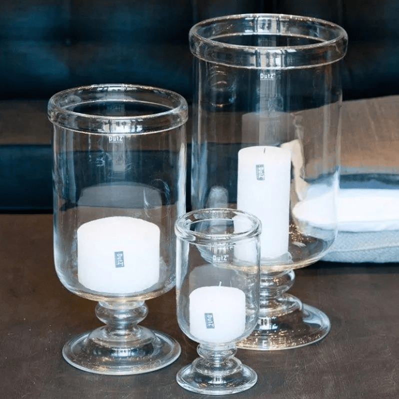 Lowlands Design clear glass hurricane vase candle holders in three sizes with white candles inside