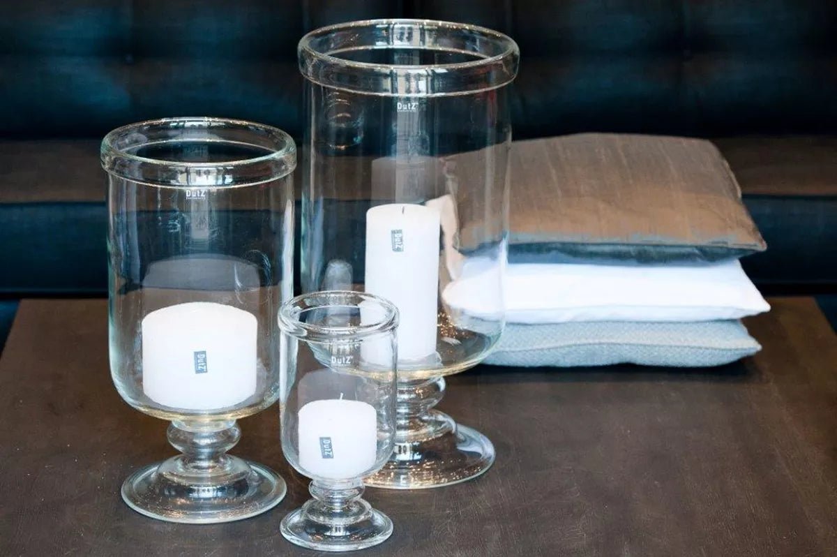 Lowlands Design clear glass candle holders in three sizes featuring hurricane vase style on wooden table