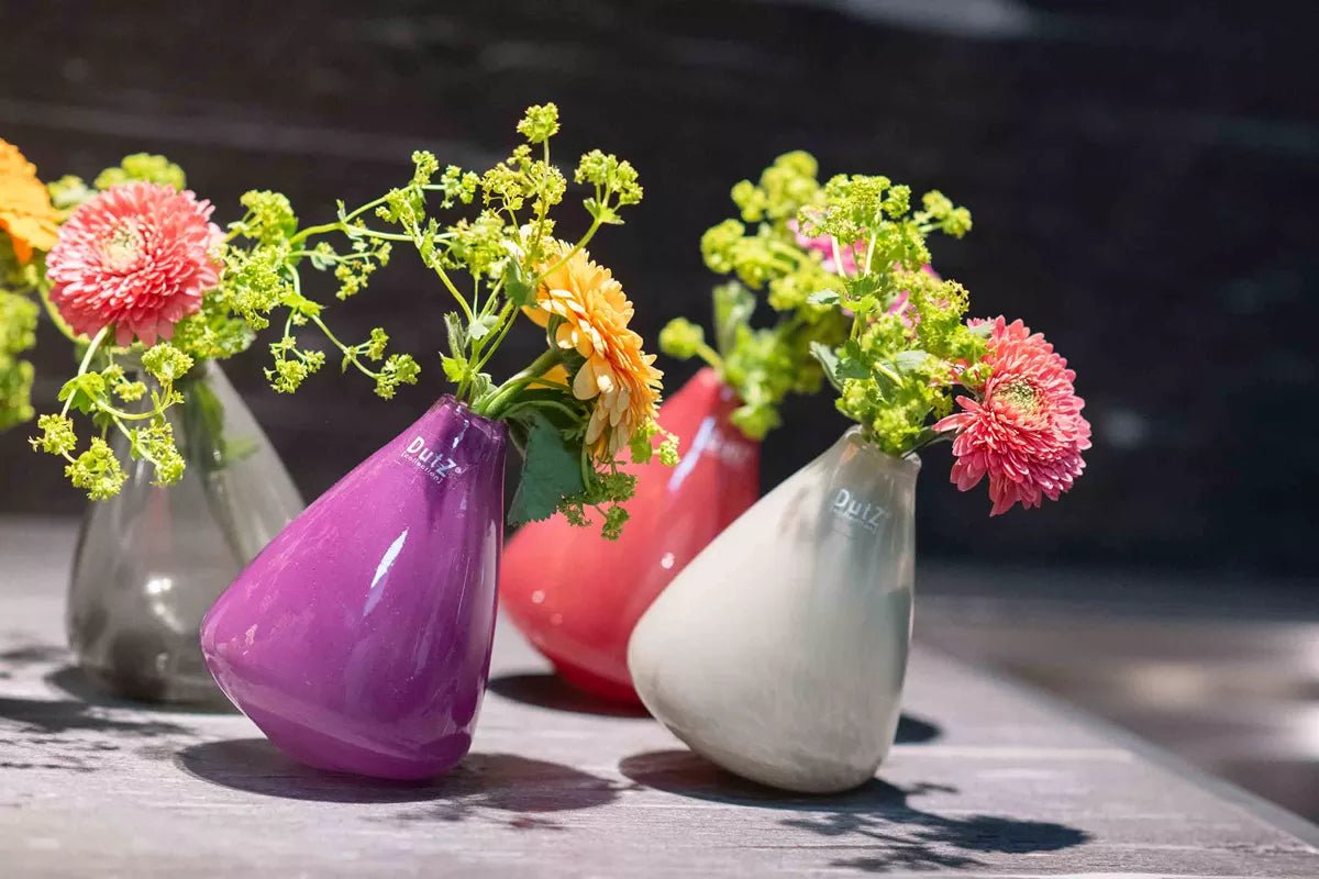 Lowlands Design colorful tumbling vase set with fresh flowers in purple red gray on wooden surface