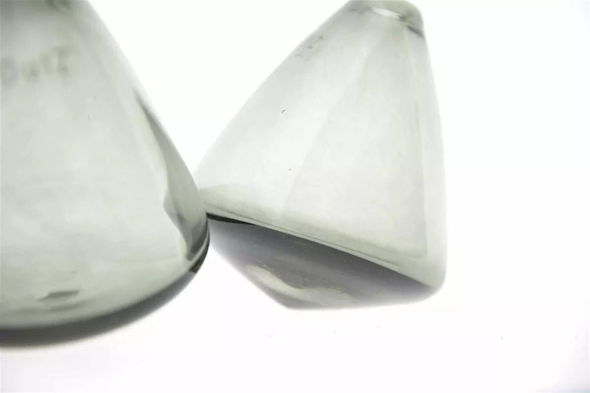 Lowlands Design tumbling vase in translucent grey glass with unique tilted shape on white background