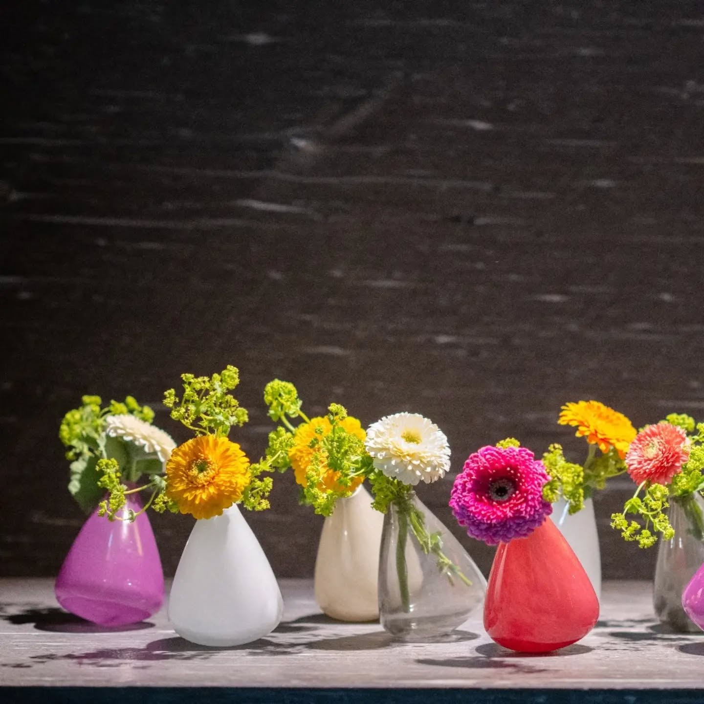 Colorful tumbling vase collection by Lowlands Design with fresh flowers in various shades