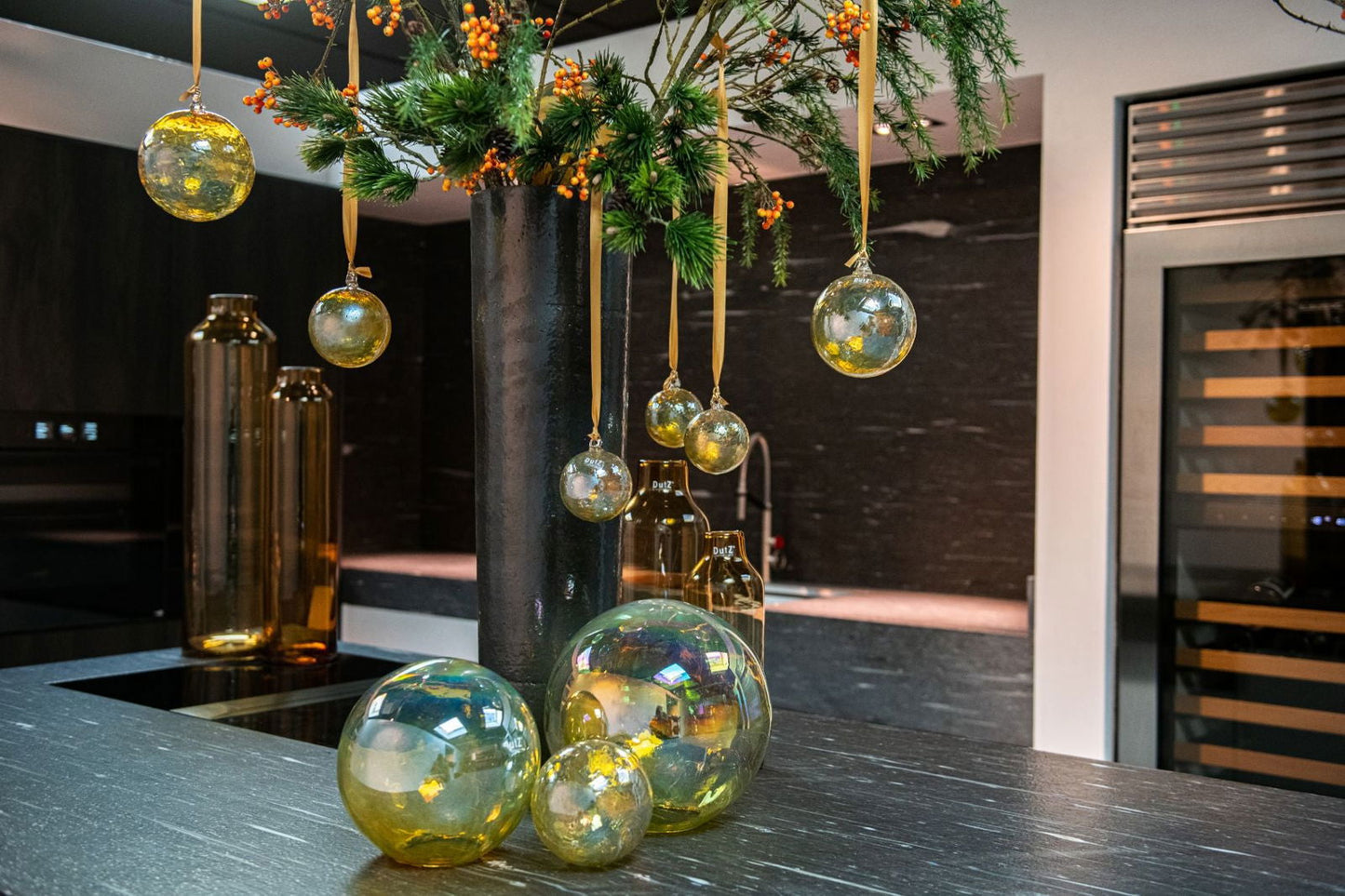 Lowlands Design glass cylinder vase with hanging and tabletop decorative spheres in a modern kitchen