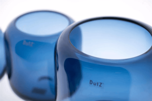 Close-up of blue glass vase by Lowlands Design with smooth rounded edges and glossy finish