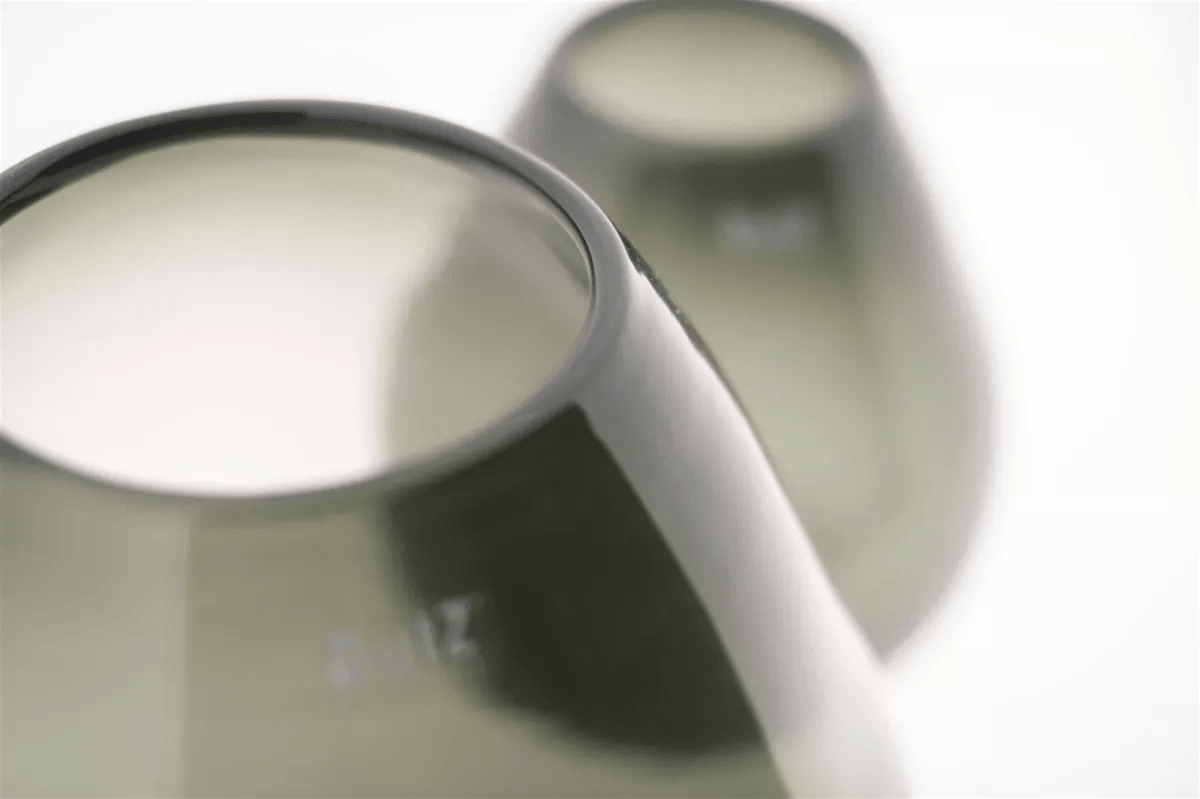Close-up of two sleek Lowlands Design vases with smooth, modern contours in muted green