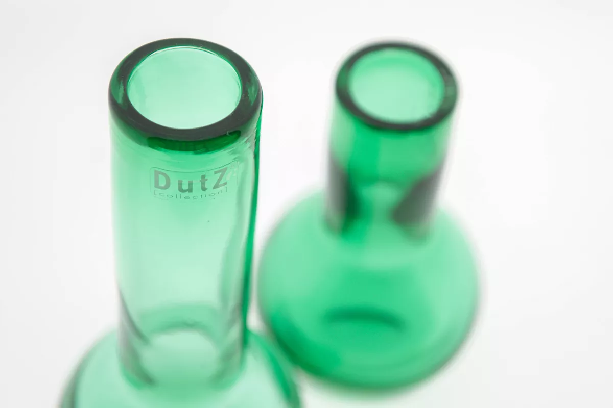 Close-up of green glass vase by Lowlands Design with smooth cylindrical neck and rounded base