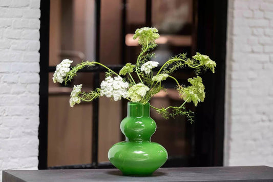 Lowlands Design green design vase with white and green flowers on a table indoors