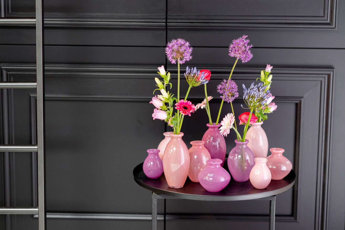 Lowlands Design pink ceramic vase set with assorted sizes and flowers on black round table