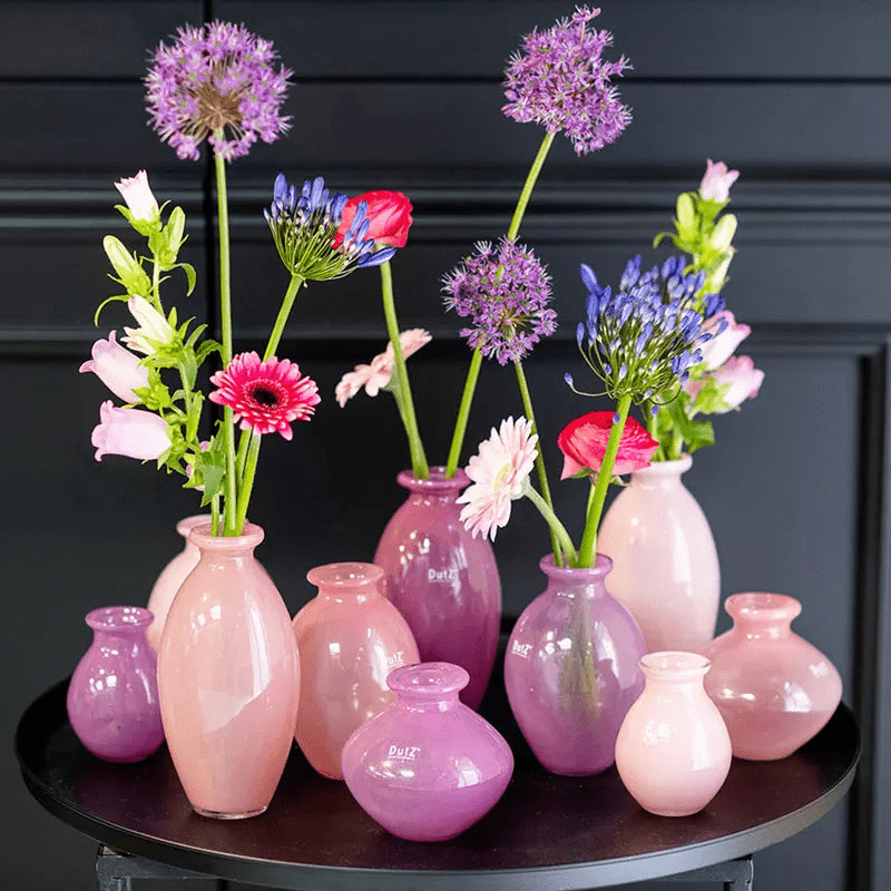 Lowlands Design pink and purple ceramic vase set with fresh mixed flowers on a black table