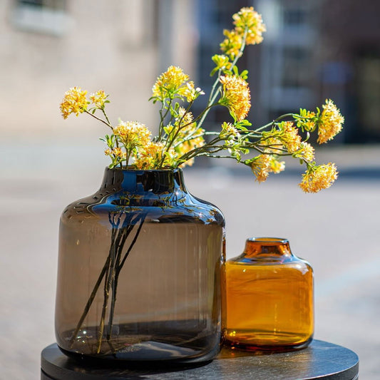Lowlands Design vase set with large smoky glass vase and smaller amber glass vase with yellow flowers
