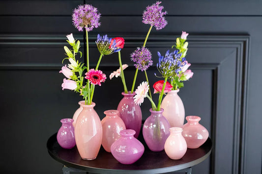 Lowlands Design pink and purple ceramic vase set with fresh flowers on a black table