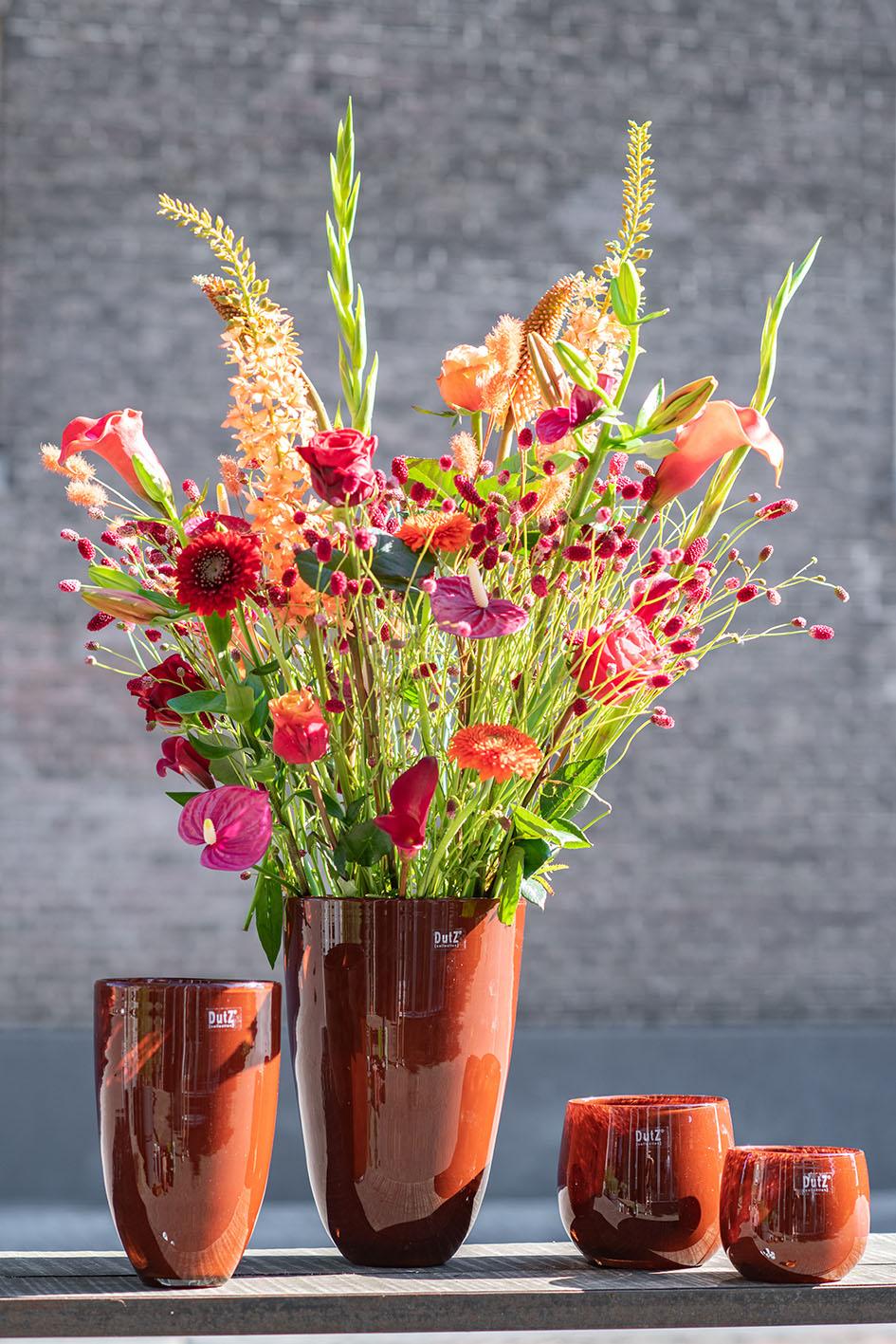 Lowlands Design flowervase glass in rich orange with a stunning floral arrangement