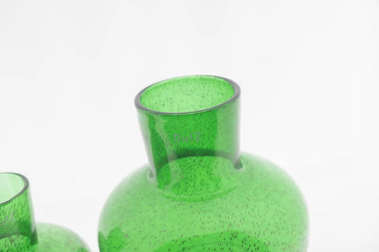 Green glass vase with a speckled texture by Lowlands Design on a white background