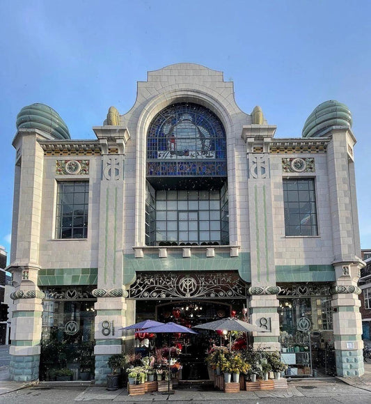 Facade of Petals Bibendum floral shop with vibrant flower displays and unique DutZ vases outside