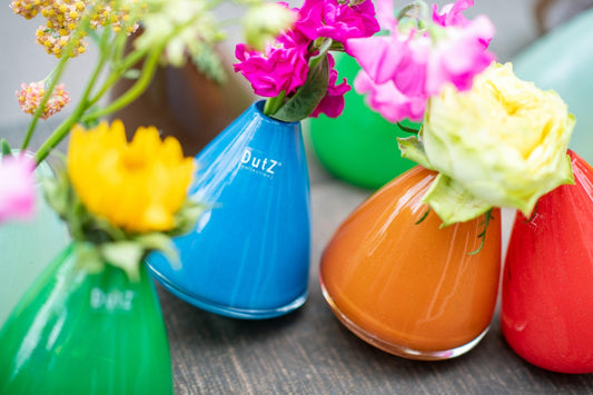 Colourful tumbling vases with fresh flowers showcasing the latest trend in decorative home accessories