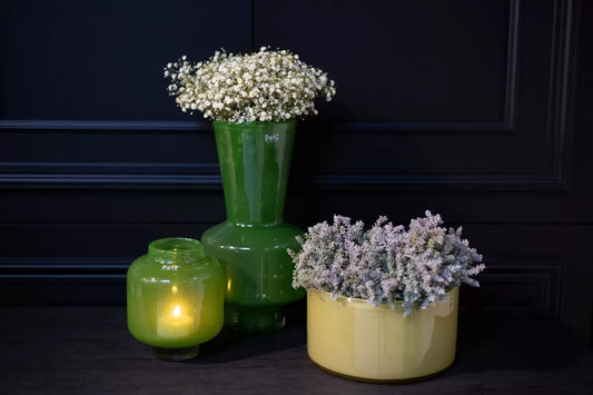 Trio with stylish jungle green decorative vase handmade with baby breath beside green candle vase and low yellow planter