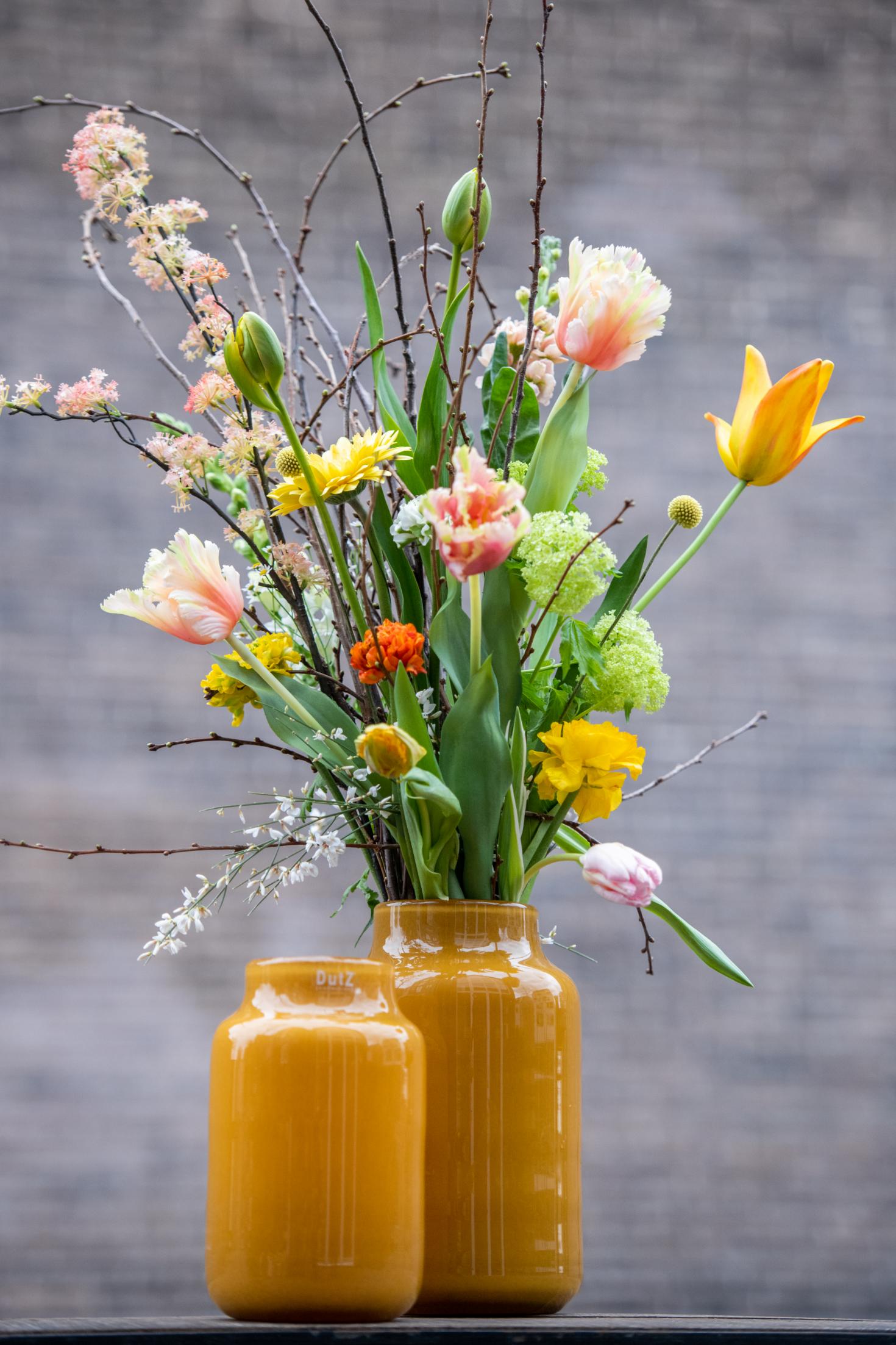 Lowlands Design Apothecary Glass Vase in amber with vibrant flowers and natural greenery