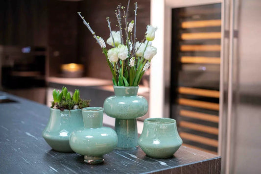Lowlands Design ceramic orchid pot set with smooth green glaze displayed on kitchen countertop