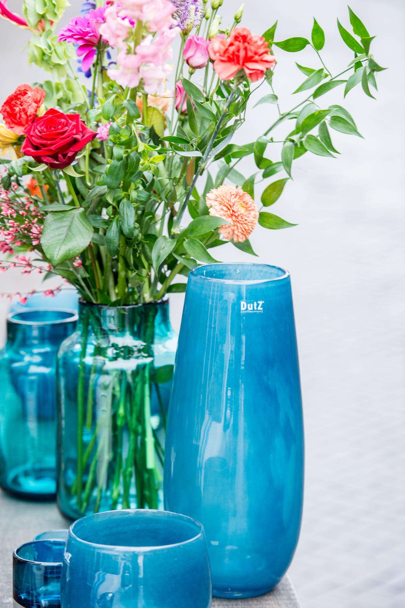 Lowlands Design blue glass flower vase showcasing vibrant floral arrangements on display