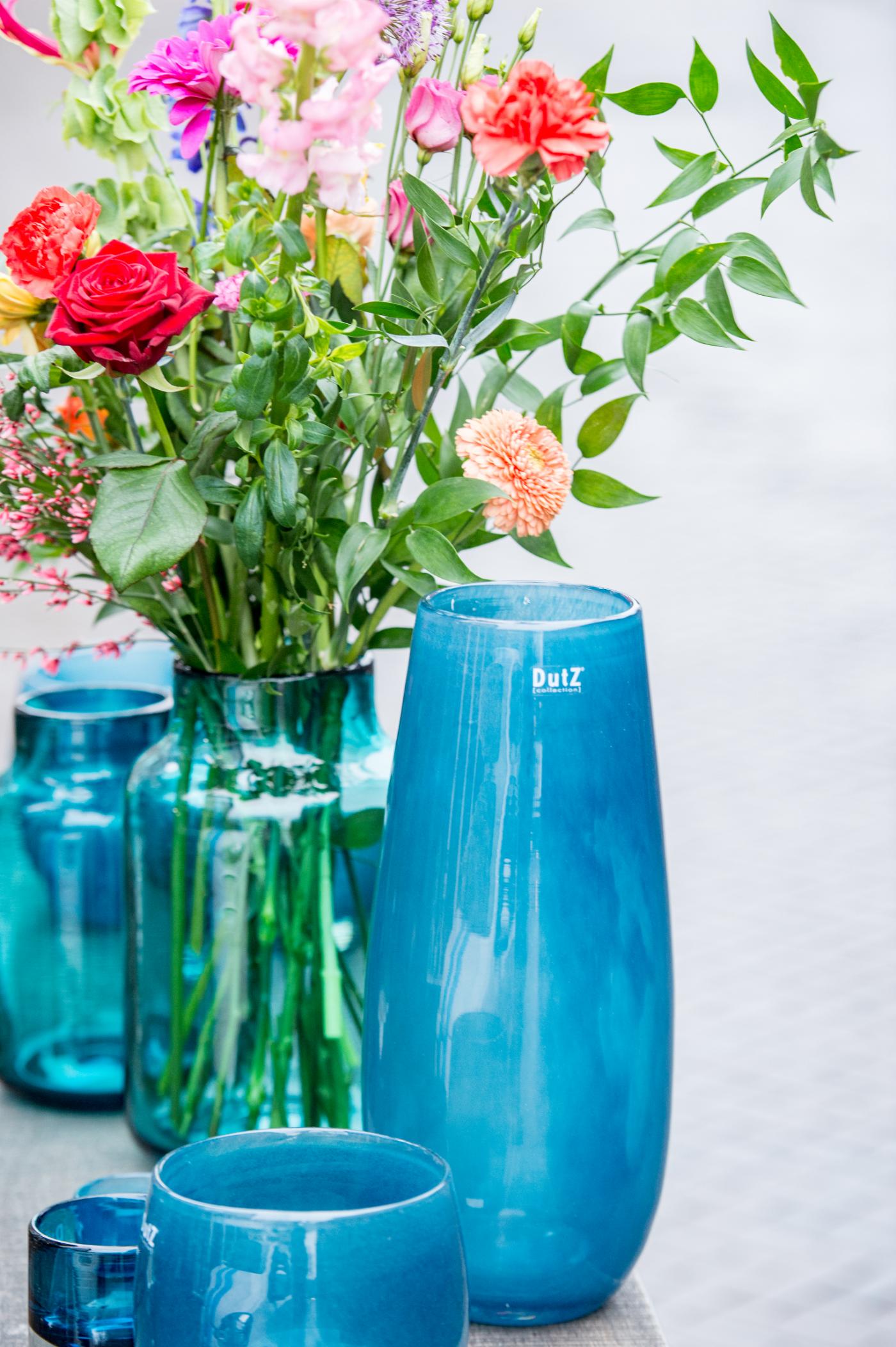 Lowlands Design blue glass flower vase showcasing vibrant floral arrangements on display