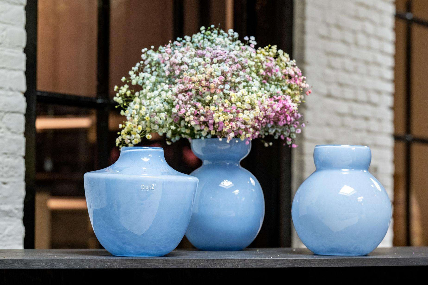 Lowlands Design baby blue glass vase trio on a window ledge with gypsophila bouquet in centre