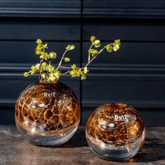 Lowlands Design brown glass ball vase with cracked pattern decoration in two sizes on table