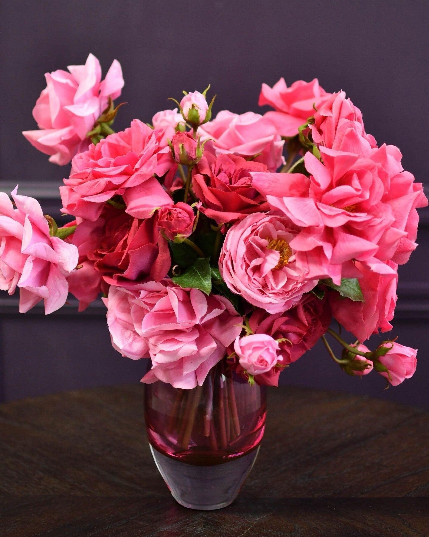Lowlands Design pink and red roses arranged in a decorative ball vase on a wooden table