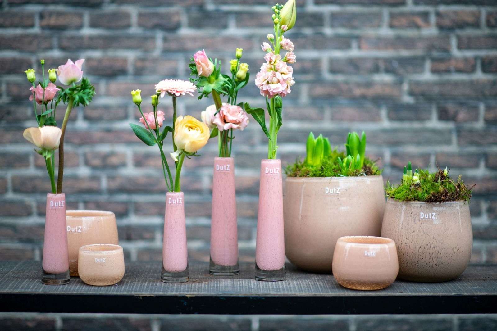 Lowlands Design Solifleur pink glass budvase set with fresh flowers and beige plant pots on wooden surface