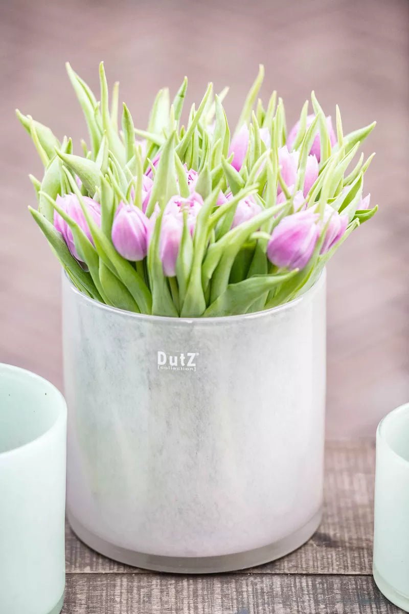 Lowlands Design silver metal cylinder vase filled with pink tulip flowers on wooden surface