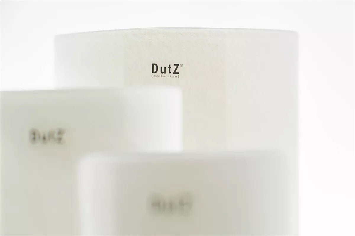 White cylinder decor pieces by Lowlands Design with minimalist DutZ branding on smooth surfaces